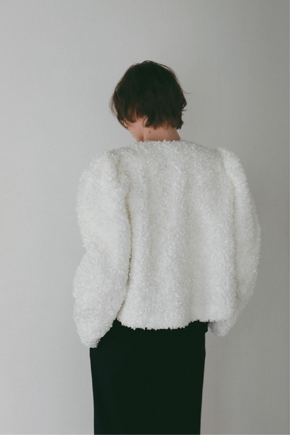 3Dレースジャケット・タックストレートパンツを着用した女性の後ろ姿の画像