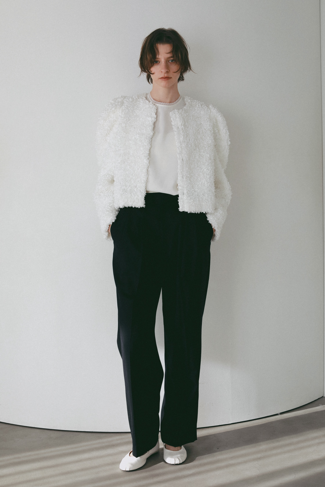 3Dレースジャケット・レーストリムブラウス・タックストレートパンツを着用した女性の画像