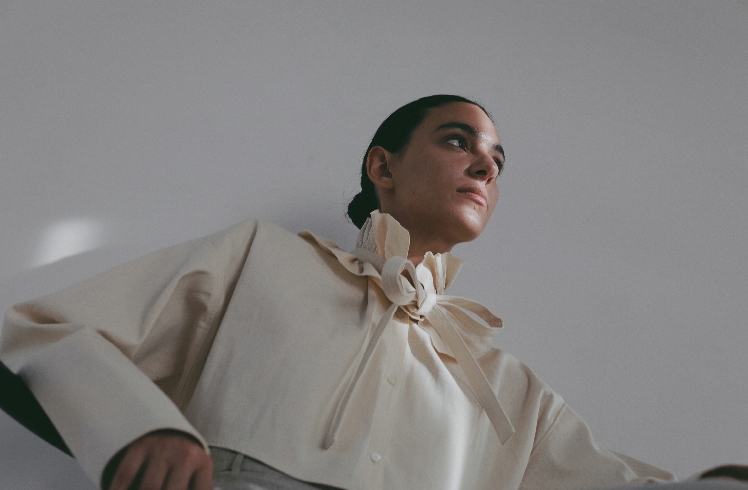 ホワイトのジャケット・ホワイトのオールインワンを着用した女性の画像