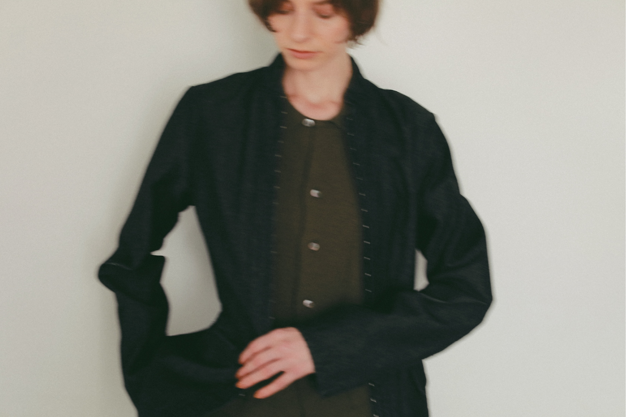 ブラックのジャケット・カーキのトップスを着用した女性の画像