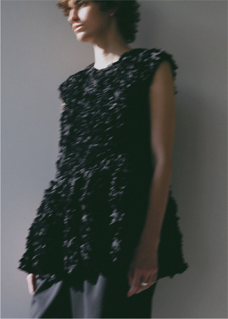 ブラックのブラウス・ブラックのパンツを着用した女性の画像