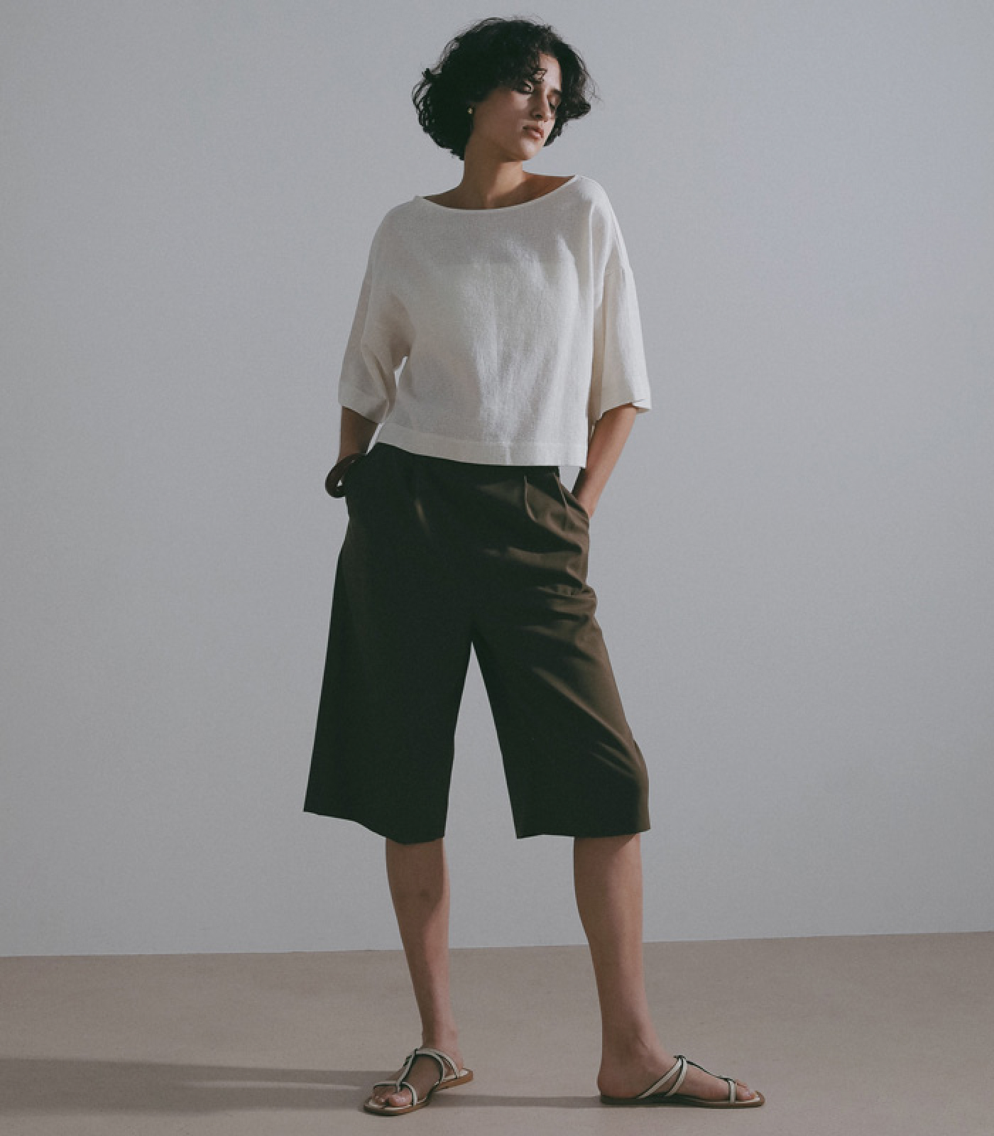 ホワイトのトップス・カーキのパンツを着用した女性
