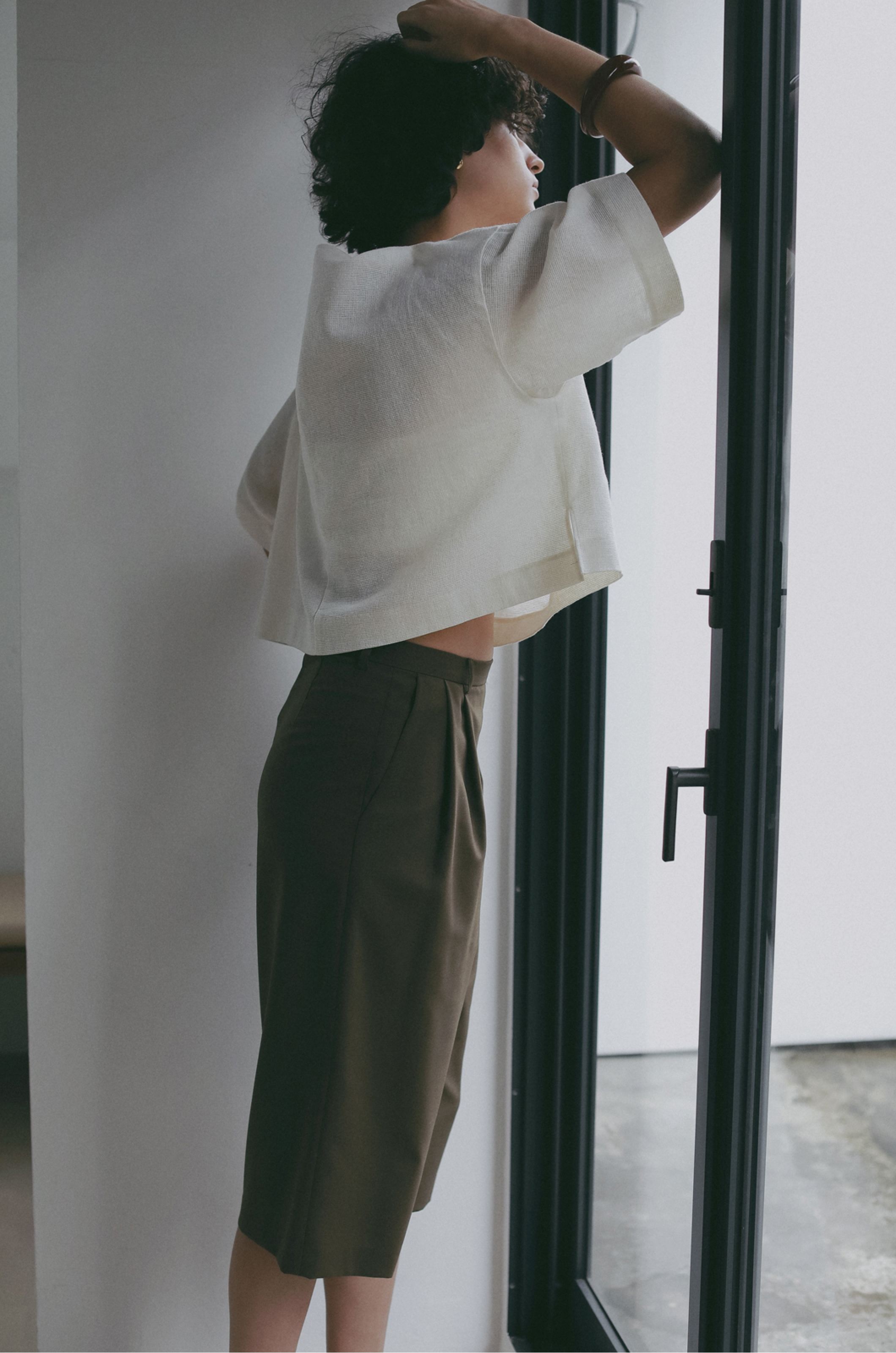 ホワイトのトップス・カーキのパンツを着用した女性